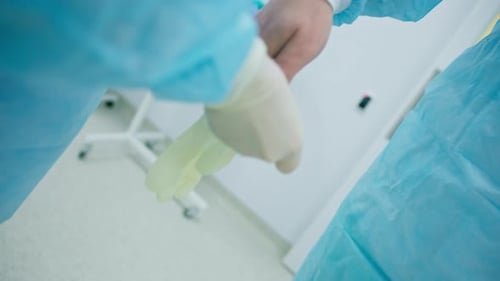Surgeon Puts on Glove in Operating Room