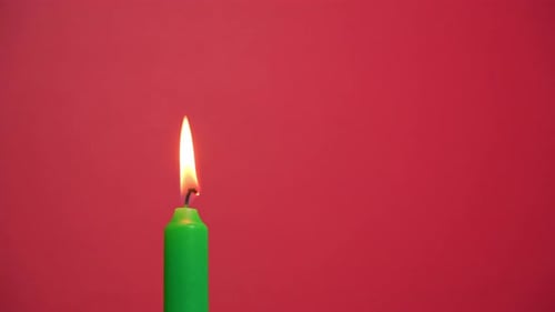 Green Candle on Red Background