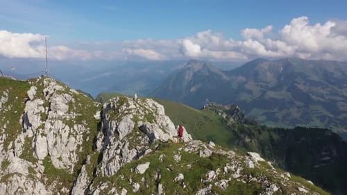 A young, fit man is seeking an adrenaline rush by running on the very narrow path or trail on top of