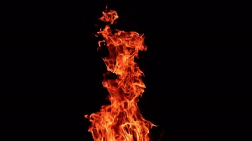 Long pillar of red flame going up into the air. Beautiful spots of sparkles flying from the fire.
