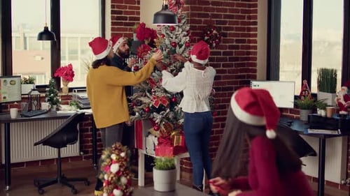 Colleagues Decorating Christmas Tree in Office