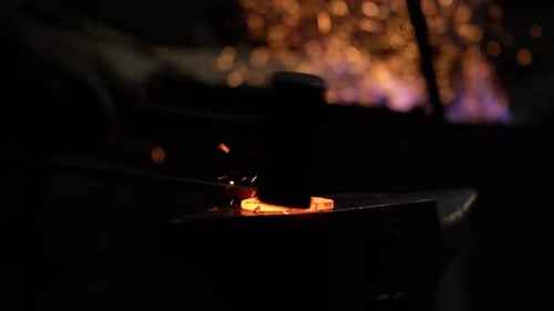 Blacksmith Shaping Hot Metal on Anvil with Hammer