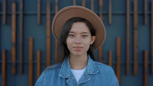 Portrait of the Beautiful Asian Woman with Freckles Looking at the Camera Wearing Brown Hat