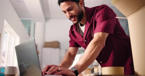 Young Man Working on Laptop at Indoor Workplace