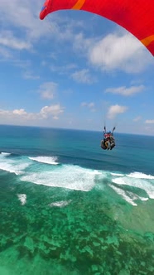 FPV Drone Shot of Paragliders Gliding Over Ocean and Cliffs in Bali Indonesia
