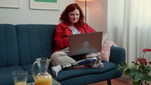Beautiful Confident Blogger Woman with Bionic Artificial Leg Using Laptop Leading Live Stream Online