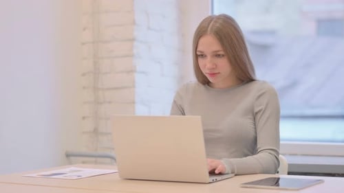 Frustrated Woman Working on her Laptop at Desk
