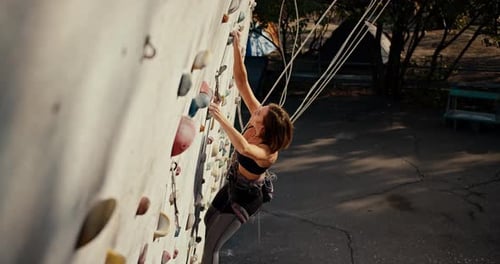 Top View of a Blonde Girl with a Bob Hairstyle in a Black Top and Black Pants She Climbs a Special