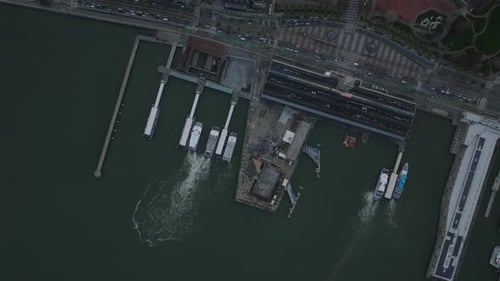 Top Down Shot of Boats and Piers at Bank in City Slowly Moving Vehicles on Busy Coastal Road