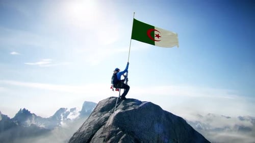 Alpiniste tenant le drapeau algérien au sommet de la montagne