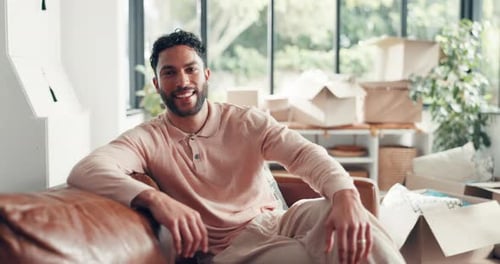 Face, new home and man on sofa, boxes and real estate with future, relax and mortgage