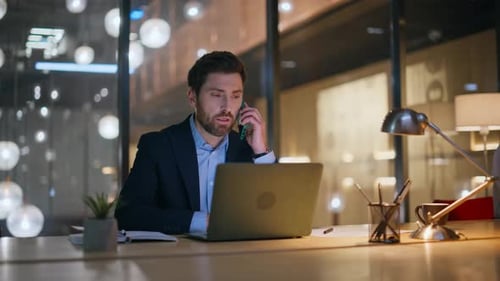 Man in Suit Talking on Phone at Desk