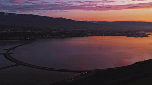 Aerial View of Icelandic Fjord at Sunset with Town and Mountains