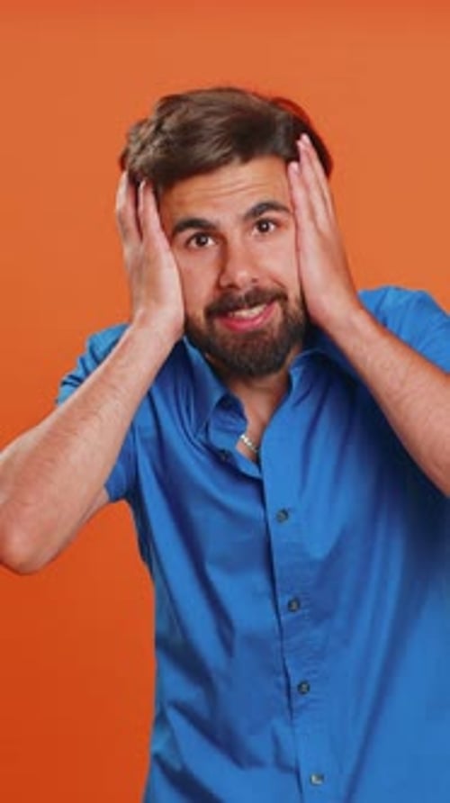 Man Expressing Confusion and Frustration on Orange Background