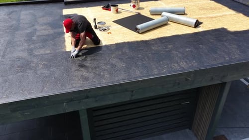 Roof Installation Process With Rolled Materials at Modern Building Site
