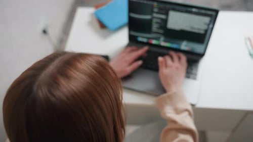 Woman Uses Laptop to Write Scripts Caucasian Woman Concentrates While Programming at Desk Focused