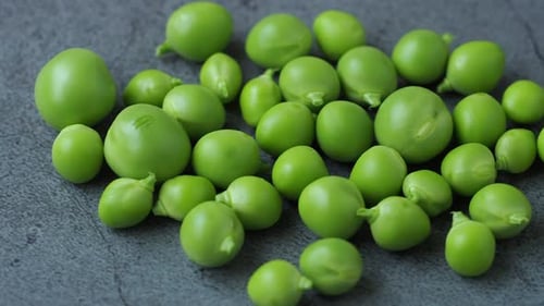 Few green peas on black background