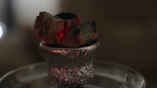 Hot ember on a hookah set lights up turning red when vaping.