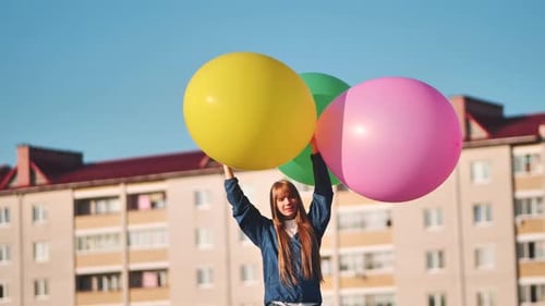 Happy Girl with Big with Colorful Balloons Posing on the Background of City Houses