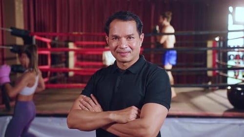 Porträt eines asiatischen männlichen Schiedsrichters, der die Regeln des Boxkampfs durchsetzt.