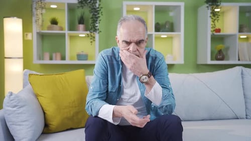 Der alte Mann schaut auf seine Uhr und wartet auf jemanden.