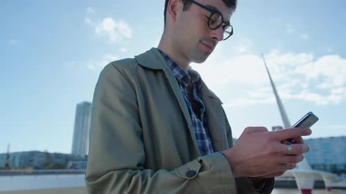 Young Businessman Texting on the Phone Outdoors in the City