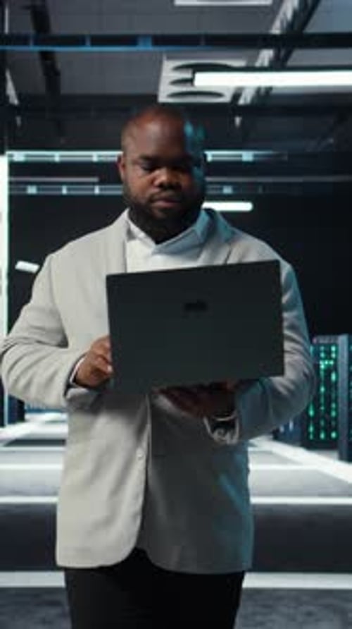 Vertical Video Data Center System Administrator Coding on Laptop Doing Software Updates
