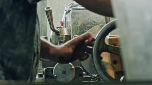 Metal worker using lathe machine in industrial workshop