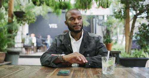 4k video footage of a young man checking the time while waiting at a restaurant