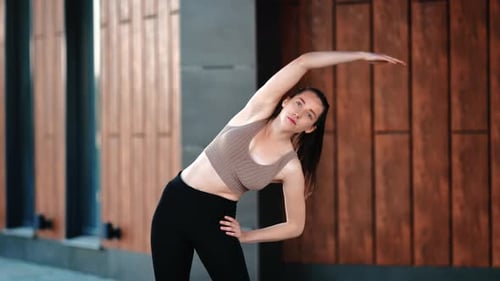 Young Fitness Woman Training Stretching Body Raising Hands Exercising Outdoor City Building Exterior