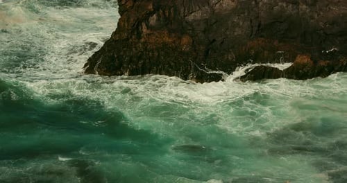 Stormy Severe Ocean Waves Foaming and Crash on Rocky Volcanic Beach