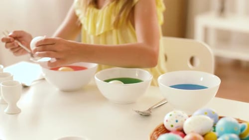 Easter, Holidays and People Concept - Happy Girl Coloring Eggs by Liquid