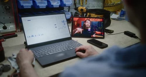 Employee Remote Learning Trading During Working Hours in Workshop Using Laptop and Digital Tablet