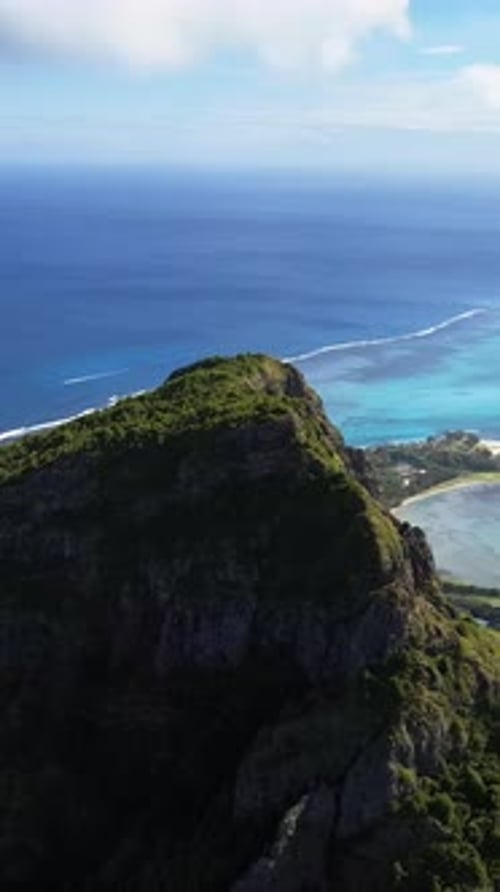 Aerial drone view past Le Morne Brabant mountain in Mauritius, overlooking the turquoise lagoon and