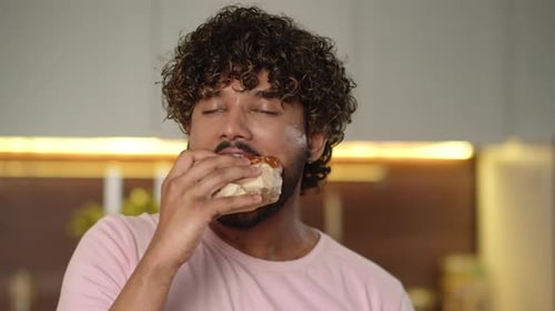 Young Adult Enjoys Burger at Home