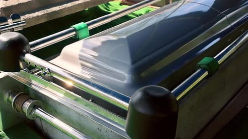 Coffin Resting on a Green Velvet Drape During a Solemn Ceremony at a Cemetery