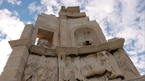 Monument de la colline de Philopappou à Athènes, avec des nuages en arrière-plan.