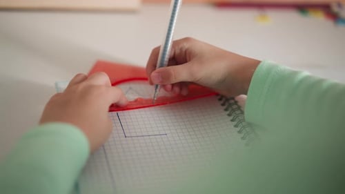 Little Student Draws Triangular Shape with Ruler and Pen