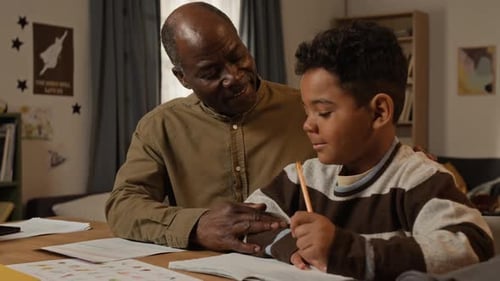 Black Father Helping Son with Writing and Spelling Homework
