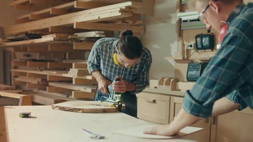 Two Handsome Young Men Carpenter Working in a Studio Wearing Safety Glasses