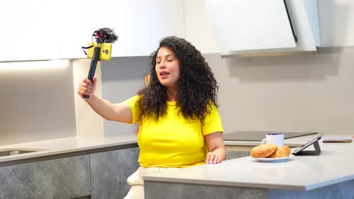 Gravação de vlogger de vídeo usando celular enquanto toma café da manhã em casa