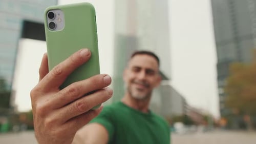 Close-up of middle-aged man's hand taking selfie on mobile phone