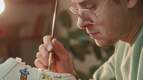 Creative Man Drawing Colorful Pictures on White Sneaker