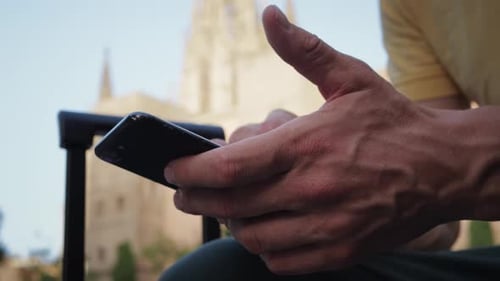 Person Using Mobile Phone in Urban Setting