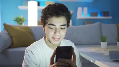 Young Adult Using Smartphone in Home Interior