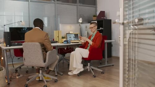 Colegas de trabalho multinacionais conversando no escritório da Agência de Marketing