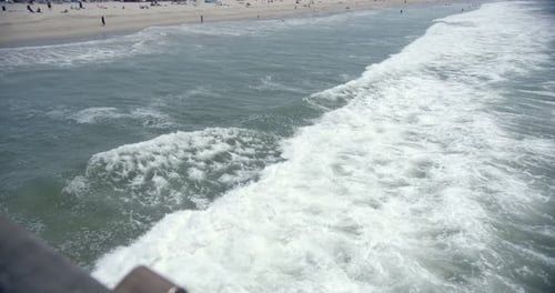 Following a wave moving towards the Los Angeles Venice Beach during a sunny day of summer, holiday d
