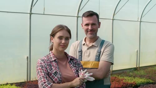 Farmers Smiling Together in Greenhouse Portrait