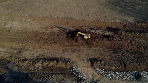 Excavator Digging in Rural Field Aerial Shot