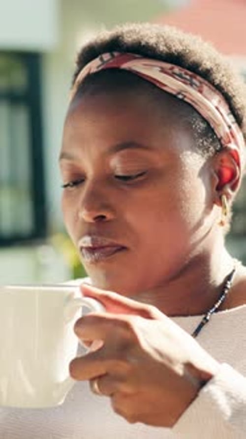 Woman Enjoys a Refreshing Beverage Outside Home